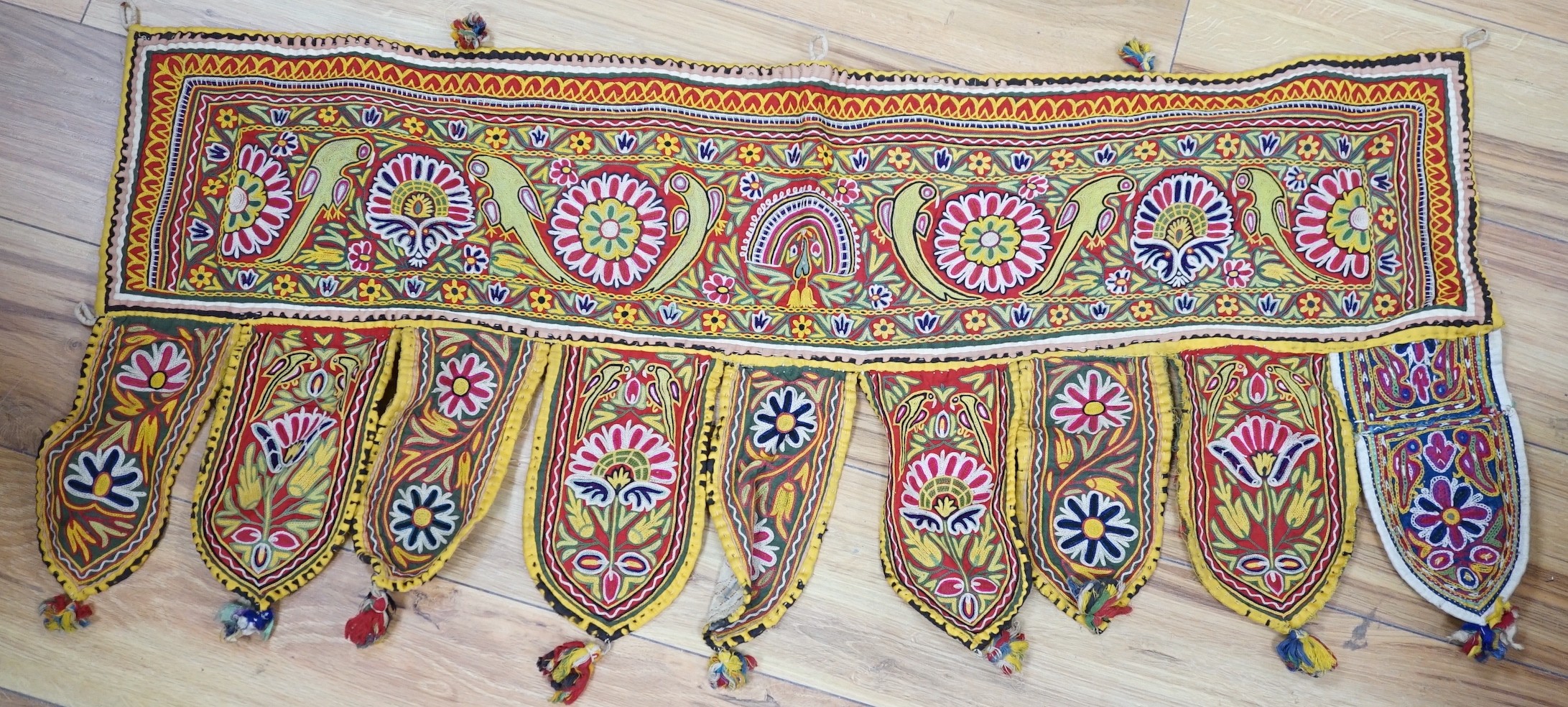 A collection of Indian mirrored worked hangings, a length of batik fabric and a woven shawl